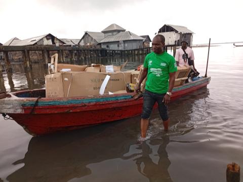 Boat transporting boxed solar freezers to Oyorokoto.